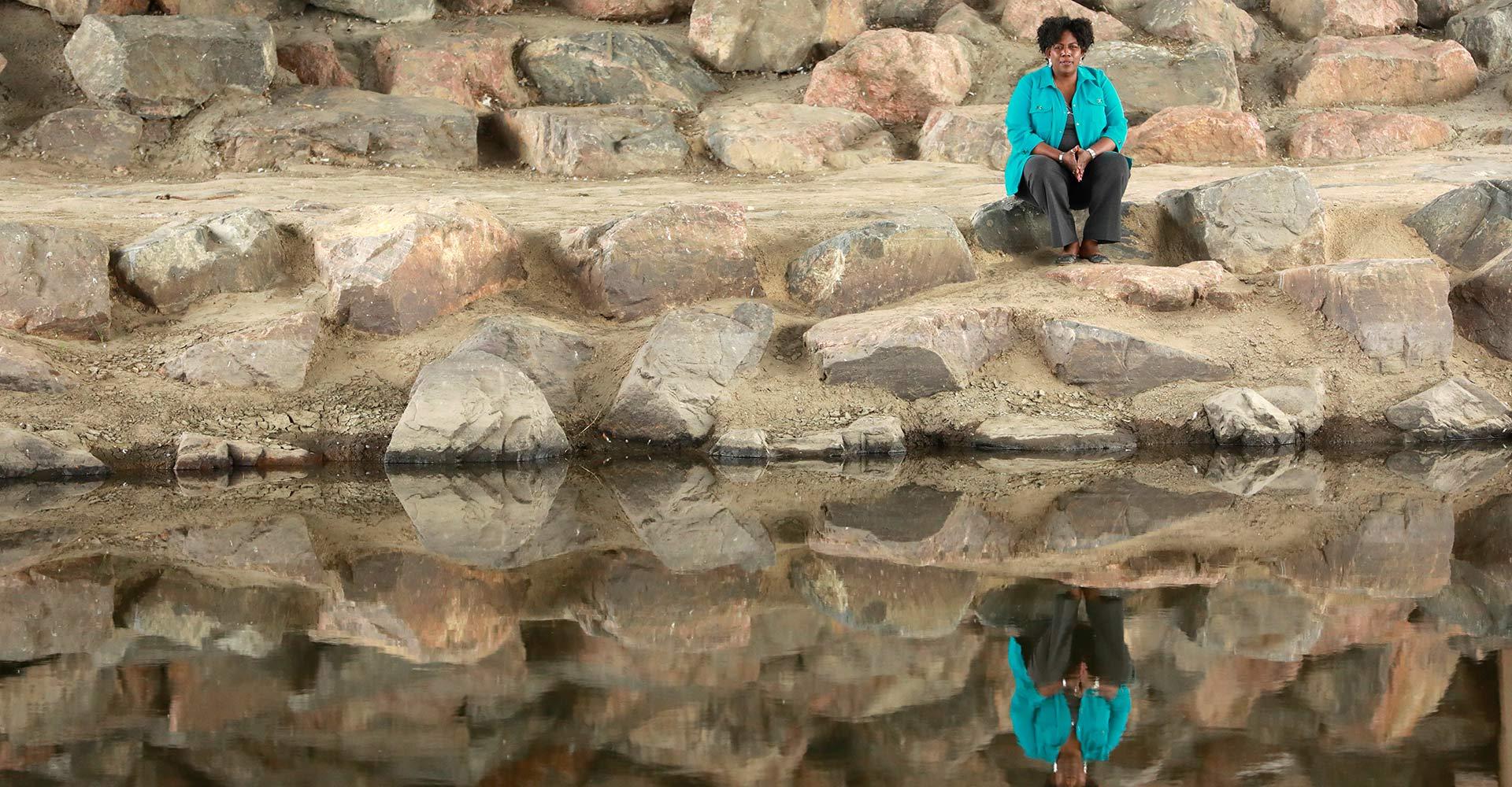 Woman overlooking river with her reflection showing