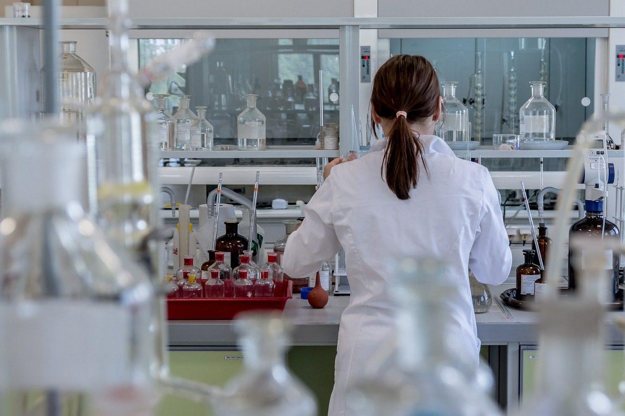 A scientist in a white coat working in a laboratory.